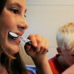 Woman and a kid brushing their teeth