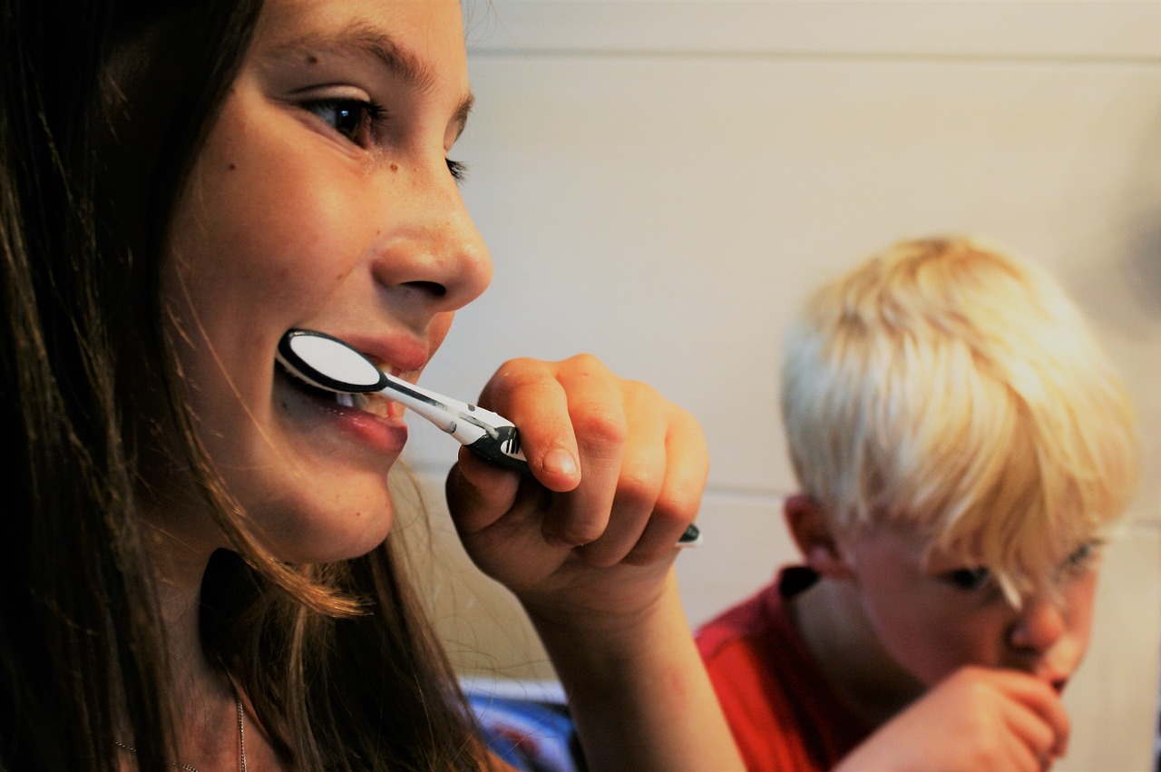 Woman and a kid brushing their teeth